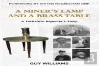 A Miners Lamp And A Brass Table